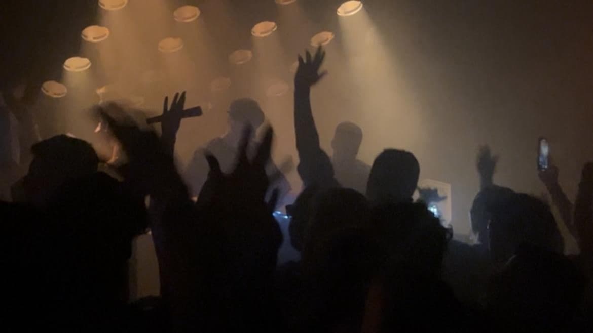 People jumping around in a nightclub.